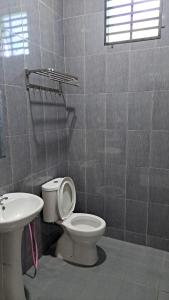 a bathroom with a toilet and a sink at Aja Retreat Bungalow OnlyMuslim in Jitra +2 photos