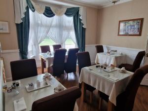 a dining room with tables and chairs and a window at Diadem Hotel in Great Yarmouth