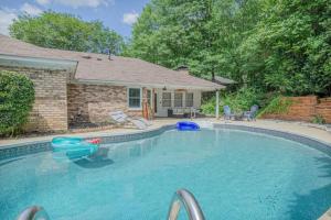 a large swimming pool in front of a house at Ultimate Getaway with Pool and Games in Columbus
