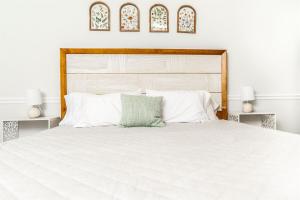 a white bed with a wooden headboard and white pillows at Ultimate Getaway with Pool and Games in Columbus +38 photos