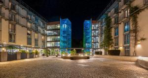 an empty street at night with tall buildings at PLAZA Residence Stuttgart-Ditzingen in Ditzingen