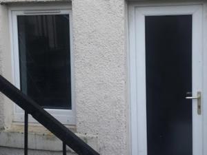 Glasgow Hampden Garden Flat في غلاسكو: باب عمارة بجانب شباك