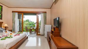 Una televisión o centro de entretenimiento en Gita Maha Ubud Hotel by Mahaputra-CHSE Certified