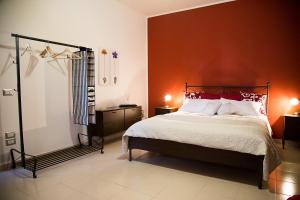 マテーラにあるA Casa Di Rosaのベッドルーム1室(オレンジ色の壁のベッド1台付)