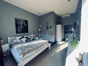 a bedroom with a large bed with blue walls at Gladstudio in Kerobokan +4 photos