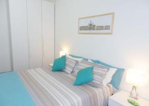 a white bedroom with a bed with blue pillows at Casa Vacanze Ricordi Romani in Rome