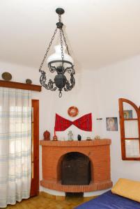 a chandelier hanging over a fireplace in a living room at Elia Apartments Sithonia in Elia