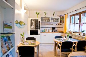 a kitchen and dining room with two tables and chairs at Ferienwohnung AmmerZonas & AmmerZone in Oberammergau