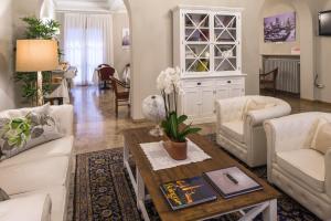 a living room with white furniture and a table at Hotel Accademia in Bologna