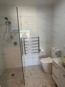 a bathroom with a toilet and a glass shower at Two bedrooms Escape to Countryside Retreat in Wamboin