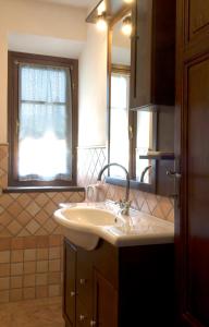 a bathroom with a sink and a mirror and a window at Casa il Ponte in Chianni