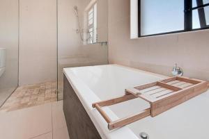 une salle de bain avec baignoire et douche en verre dans l'établissement Spacious Room with Balcony, Mountain Views, Modern Bathroom Tub and Shower and WiFi, au Cap 15 autres photos