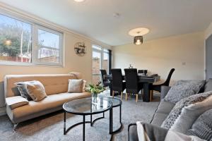 a living room with a couch and a table at Large spacious and spotless house with hot tub and snooker and table tennis NEC,JLR,Airport Sleeps 8 in Water Orton