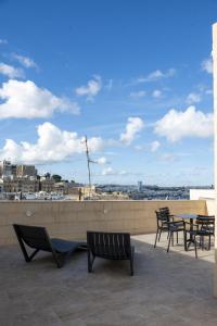 a group of chairs and tables on a roof at Valletta City Suites in Valletta