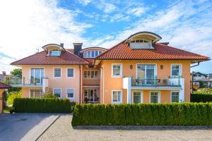 een groot oranje huis met een rood dak bij Pension Hiesel-Villa Untersbergblick in Anthering