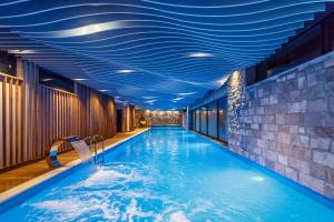 a swimming pool with blue ceilings in a hotel at Pino Nature Hotel, BW Premier Collection in Sarajevo