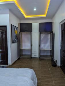a bedroom with a bed and cabinets in a room at Rosemary's Residence in Asaba