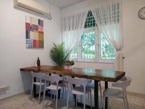 a dining room with a wooden table and chairs at Sohostay in Kuala Terengganu