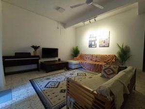 a living room with a couch and a tv at Sohostay in Kuala Terengganu