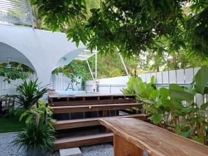 a wooden bench in a garden with a tub at Sohostay in Kuala Terengganu