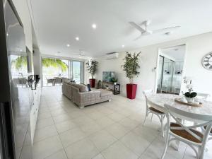 a living room with a table and a couch at Absolutely Lovely Waterfront Apartment 333 in Nelly Bay
