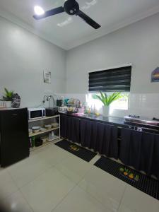 a large kitchen with a black counter top at MiNi HoMeSTaY MuslIimOnly in Banting +8 photos