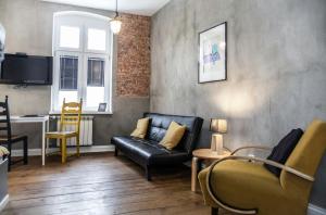 ein Wohnzimmer mit Sofa und Tisch in der Unterkunft Loft Rooms - centrum - bezpłatny parking in Lyck