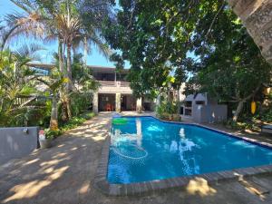 a swimming pool in front of a house at Reefteach Lodge in Sodwana Bay