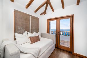 ein Schlafzimmer mit einem Bett und einem Fenster in der Unterkunft NEW! Premium Ocean Views, Corner Condo with Fireplace and Golf Cart in Avalon