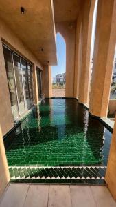 a swimming pool with green tiles in a building at Palazzo Luxury Villa 950m2, 7 bedrooms, Pickleball court, swimming pool in Ha Long