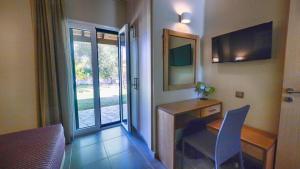 a room with a desk and a table and a window at Villa Rododafni in Roda