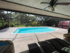 a swimming pool in a backyard with a ceiling at Heated pool at Persimmon Retreat in West Palm Beach