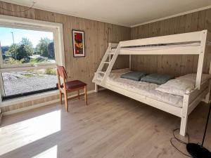 1 dormitorio con litera, silla y ventana en 10 person holiday home in Stathelle-By Traum, en Stathelle
