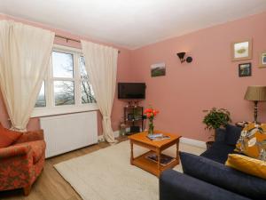 a living room with a couch and a table at Holly Cottage in Malvern Wells