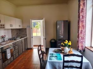 a kitchen with a table with chairs and a refrigerator at 19 On Hurd in Newton Park +14 photos
