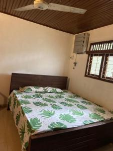 - une chambre avec un lit et une couette verte et blanche dans l'établissement Madiha home staying, à Matara