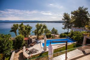 - une vue sur l'eau depuis une maison avec piscine dans l'établissement Apartments Ana, à Malinska