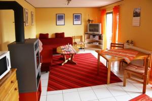 a living room with a red couch and a red rug at Ferienwohnung-am-Kühl in Poppenhausen