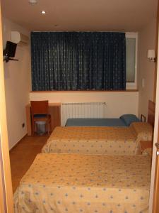 um quarto com 2 camas e uma janela em Pensió Sant Antoni em Palau d'Anglesola