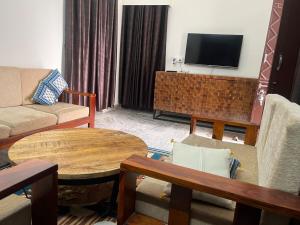 un salon avec un canapé, une table et une télévision dans l'établissement White House shikargarah Jodhpur, à Jodhpur