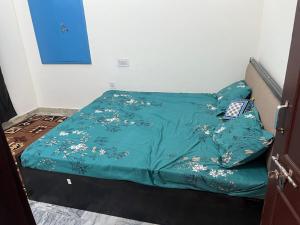 - un lit avec une couette verte au-dessus dans l'établissement White House shikargarah Jodhpur, à Jodhpur