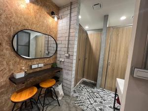 a bathroom with a mirror and two stools and a sink at Jincheng Hostel in Changhua City
