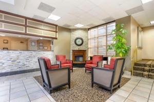 a waiting room with red chairs and a fireplace at Comfort Inn University Center in Fairfax