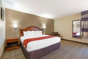 a hotel room with a large bed and a chair at Comfort Inn University Center in Fairfax