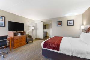 a hotel room with a bed and a flat screen tv at Comfort Inn University Center in Fairfax