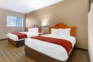 a hotel room with two beds with red and white sheets at Comfort Inn University Center in Fairfax