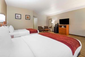 a hotel room with a large bed and a flat screen tv at Comfort Inn University Center in Fairfax
