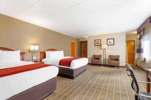 a hotel room with two beds and two chairs at Comfort Inn University Center in Fairfax