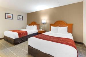 a hotel room with two beds with red and white sheets at Comfort Inn University Center in Fairfax