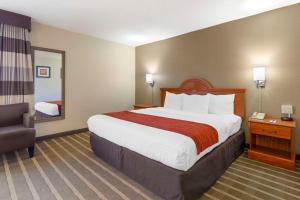 a hotel room with a large bed and a chair at Comfort Inn University Center in Fairfax